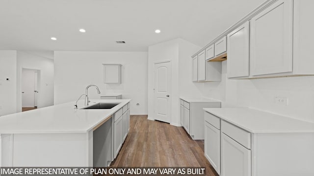 kitchen with an island with sink, sink, and light wood-type flooring