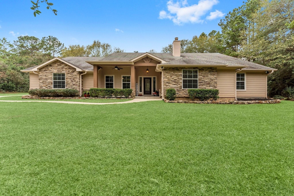 ranch-style home with a front lawn and ceiling fan