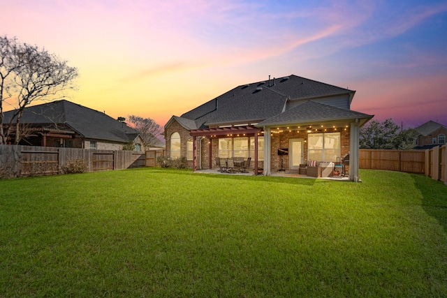 back house at dusk featuring a pergola, a patio area, outdoor lounge area, and a lawn