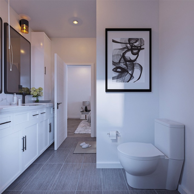 bathroom featuring baseboards, vanity, and toilet