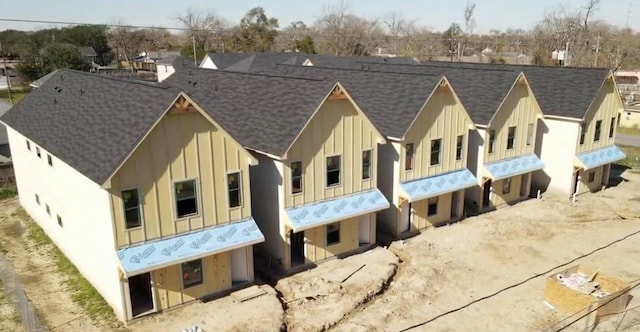 exterior space featuring board and batten siding and roof with shingles