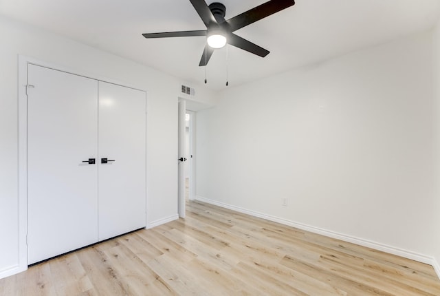 unfurnished bedroom featuring baseboards, visible vents, ceiling fan, light wood-style floors, and a closet