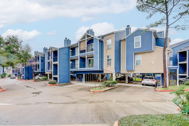 view of property with a residential view and covered and uncovered parking