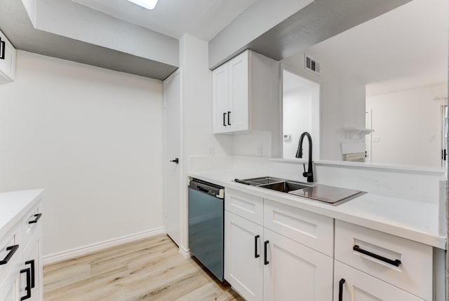 kitchen with visible vents, white cabinets, light countertops, stainless steel dishwasher, and a sink