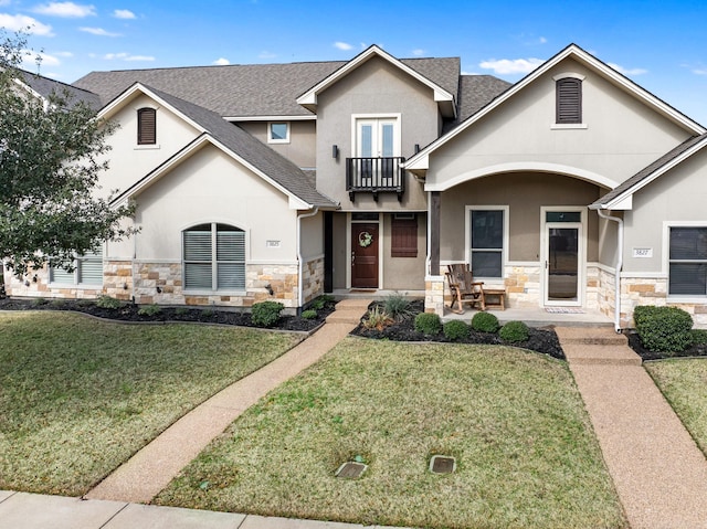 view of front of home featuring a balcony and a front yard