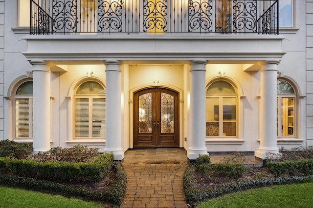 doorway to property featuring french doors and stucco siding