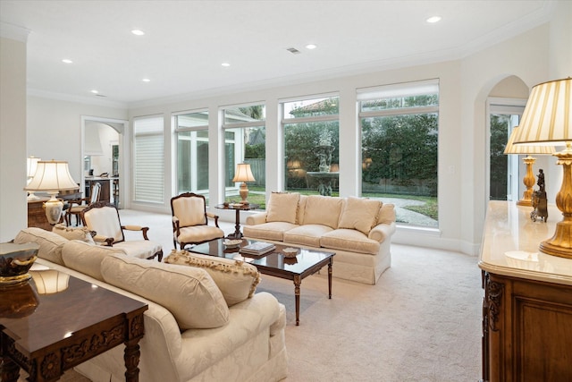 living area featuring arched walkways, ornamental molding, recessed lighting, and light colored carpet