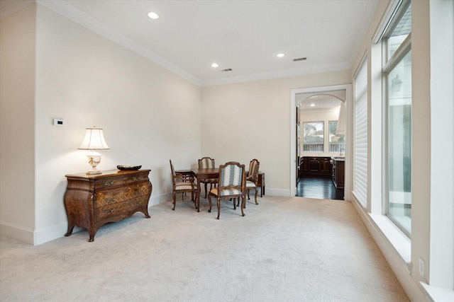 dining space with light carpet, baseboards, visible vents, and crown molding