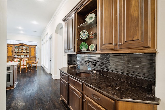 interior space featuring dark wood finished floors, crown molding, open shelves, a sink, and oven