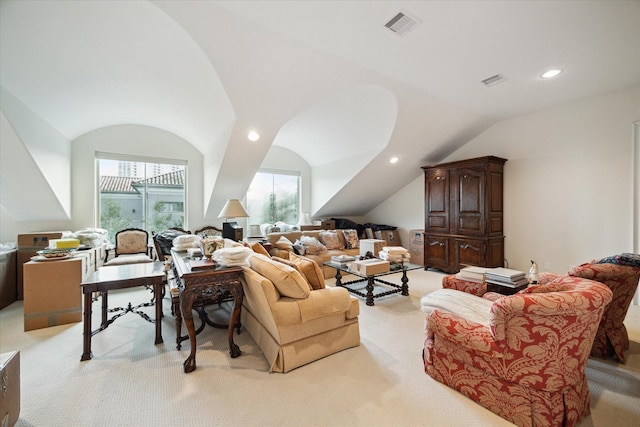 living room with lofted ceiling, plenty of natural light, visible vents, and light colored carpet