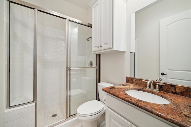 bathroom with a stall shower, vanity, and toilet