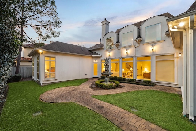 back of property featuring a patio area, a chimney, fence, and stucco siding