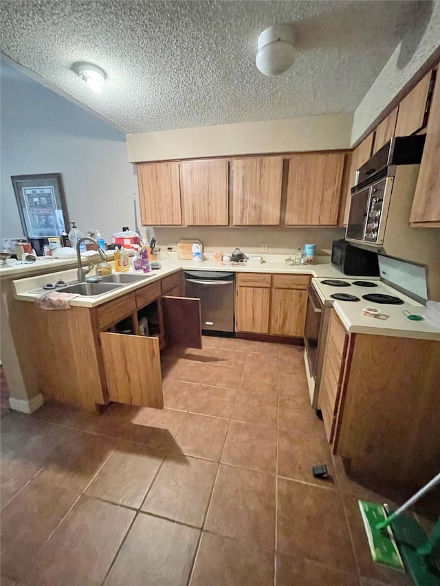 kitchen featuring sink, light tile patterned flooring, a textured ceiling, stainless steel appliances, and kitchen peninsula