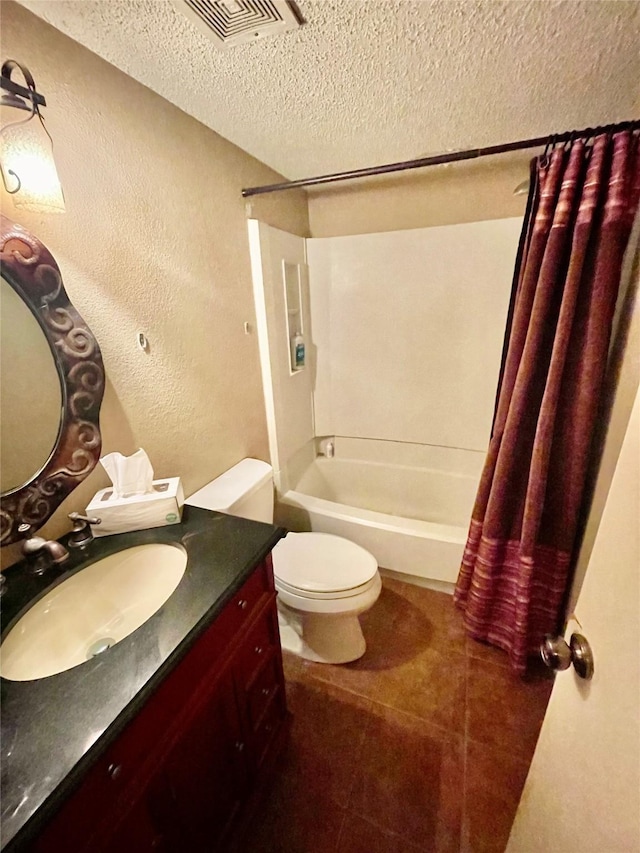 full bathroom featuring tile patterned flooring, shower / bath combo with shower curtain, toilet, a textured ceiling, and vanity