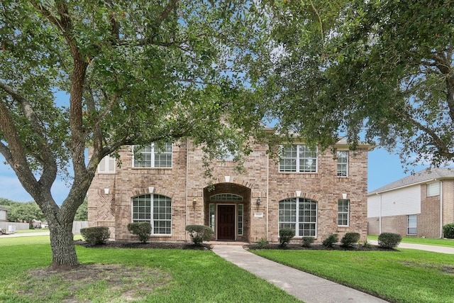 view of front of home with a front yard and brick siding