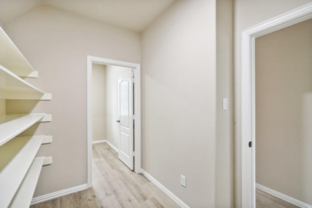 hallway with light wood finished floors and baseboards