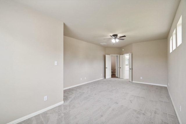 unfurnished room featuring a ceiling fan, light carpet, and baseboards