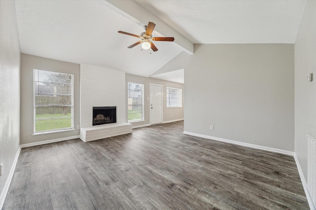 unfurnished living room with a fireplace, ceiling fan, lofted ceiling with beams, and dark hardwood / wood-style flooring