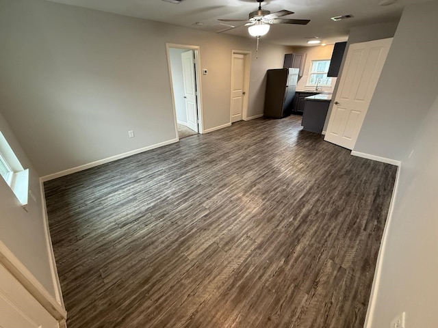 unfurnished living room featuring sink, dark hardwood / wood-style floors, and ceiling fan