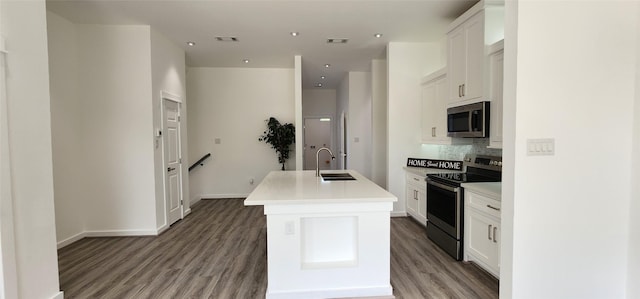 kitchen featuring appliances with stainless steel finishes, sink, a kitchen island with sink, and white cabinets