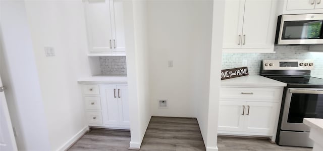 kitchen featuring white cabinetry, decorative backsplash, stainless steel appliances, and light hardwood / wood-style floors