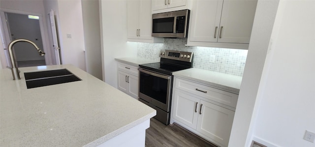 kitchen with stainless steel appliances, white cabinets, decorative backsplash, dark hardwood / wood-style flooring, and sink