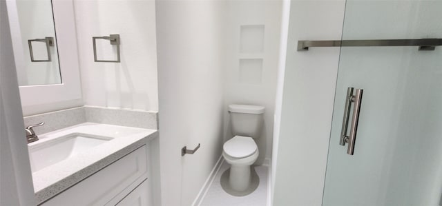 bathroom featuring toilet, vanity, and tile patterned flooring