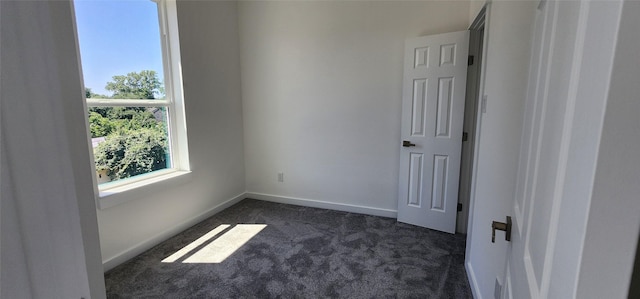 unfurnished bedroom with dark carpet