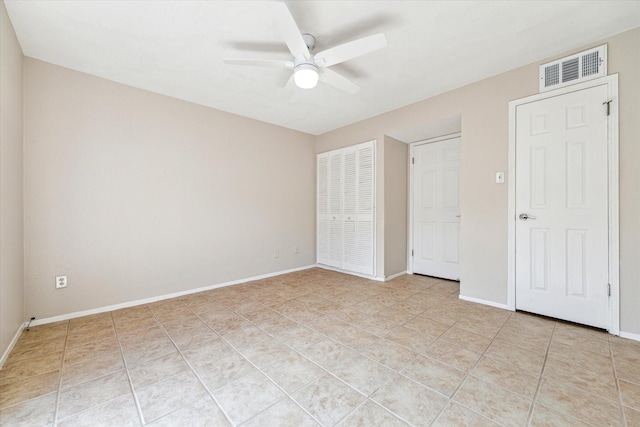 unfurnished bedroom featuring light tile patterned floors, a closet, visible vents, ceiling fan, and baseboards