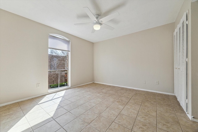 unfurnished room featuring a ceiling fan, baseboards, and light tile patterned floors