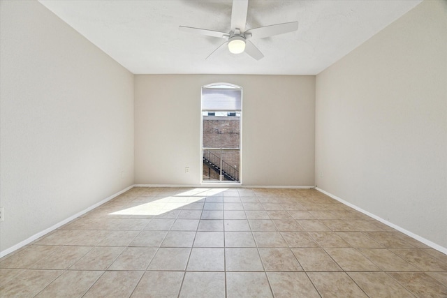 spare room with light tile patterned floors, ceiling fan, and baseboards