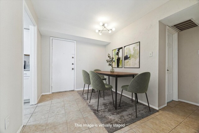 dining room featuring light tile patterned floors, baseboards, visible vents, and a notable chandelier