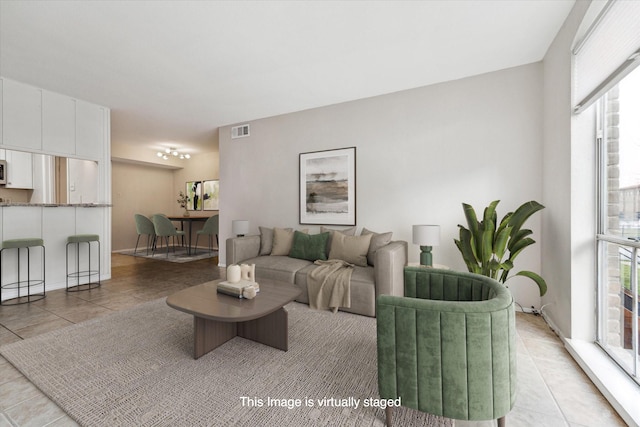 living room featuring light tile patterned floors, visible vents, and a wealth of natural light