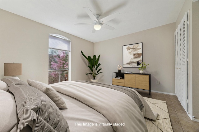 bedroom featuring light tile patterned floors, baseboards, and a ceiling fan