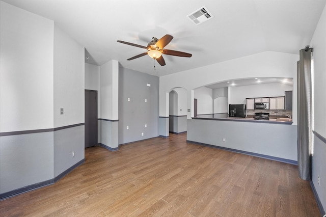 unfurnished living room with hardwood / wood-style floors, vaulted ceiling, and ceiling fan