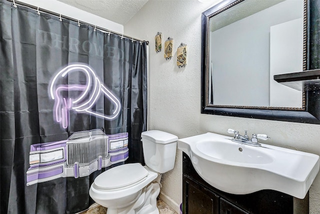 bathroom featuring a textured ceiling, vanity, and toilet