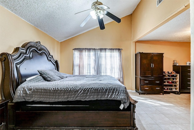 bedroom with ceiling fan, light tile patterned floors, a textured ceiling, and lofted ceiling