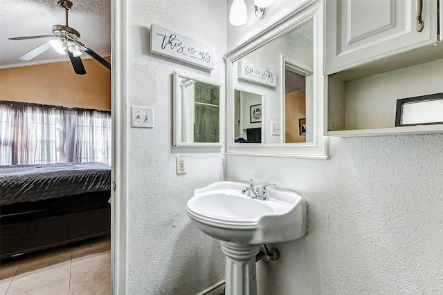 bathroom with ceiling fan, tile patterned flooring, and vaulted ceiling