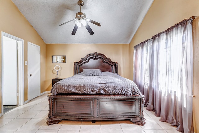 bedroom featuring a textured ceiling, lofted ceiling, ceiling fan, and light tile patterned floors