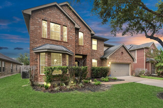 view of property featuring a garage and a lawn