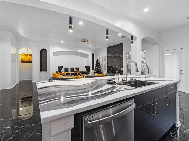 kitchen featuring stainless steel dishwasher, sink, and hanging light fixtures