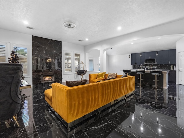 living room with a textured ceiling and a premium fireplace