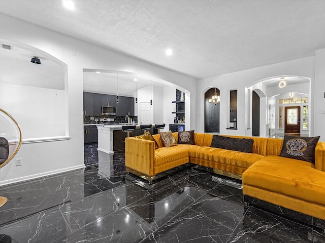 living room featuring a textured ceiling and sink