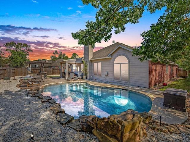 pool at dusk featuring a patio area