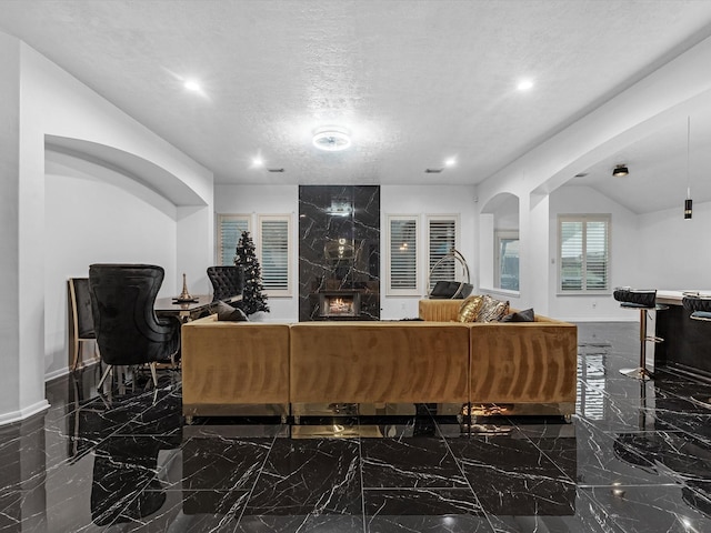 living room with a premium fireplace and a textured ceiling