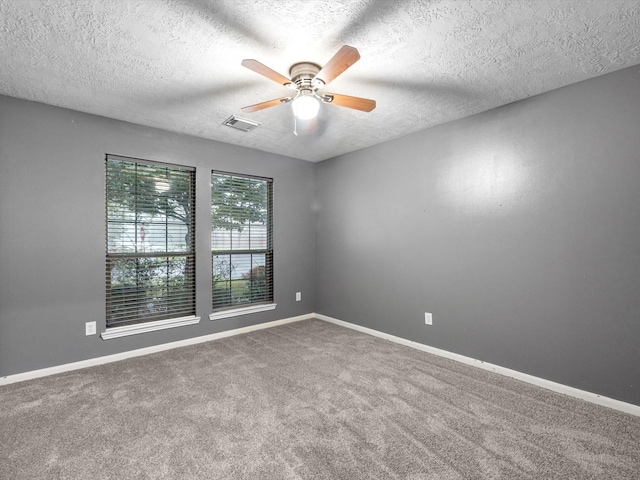 carpeted spare room with ceiling fan and a textured ceiling