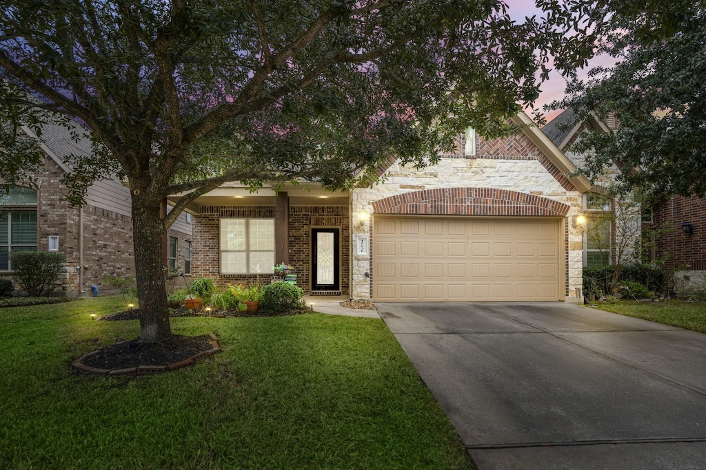 view of front of property with a yard and a garage