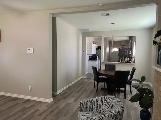 dining space with dark hardwood / wood-style flooring