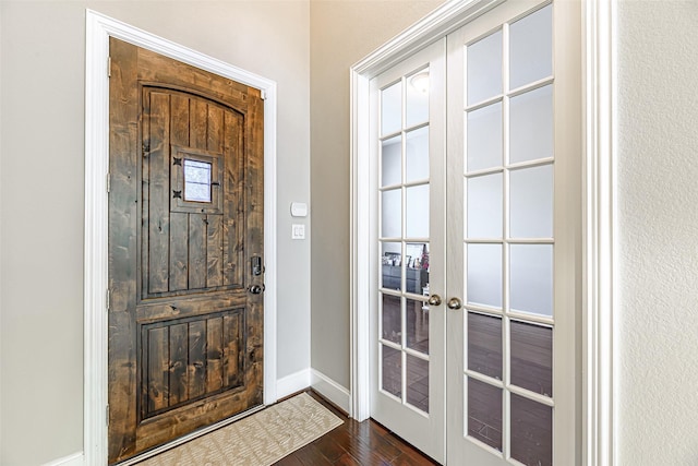 entrance foyer featuring french doors, dark wood-type flooring, and baseboards