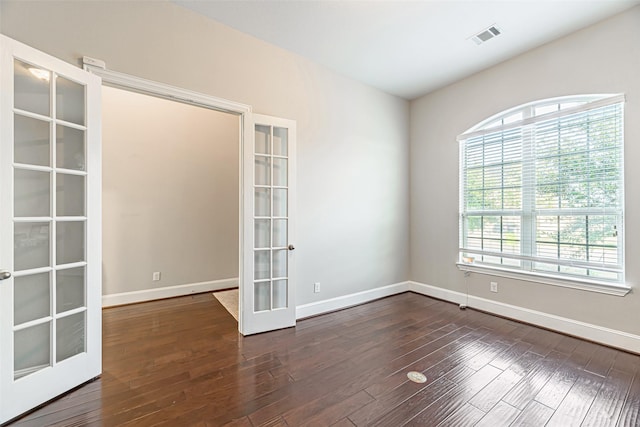 spare room with baseboards, visible vents, wood finished floors, and french doors